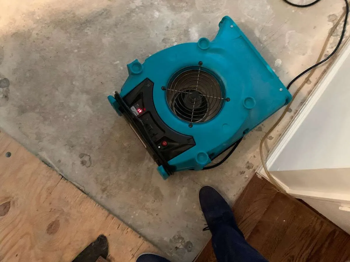 Air mover drying subfloor during Commercial Water Damage Restoration in Grayling